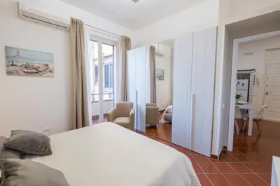 a bedroom with a bed and a living room at MEC apartment in Palermo