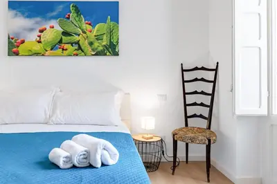 a bedroom with a blue bed with towels on it at GuestHost - Mezzojuso Central Apartment near Via Roma in Palermo