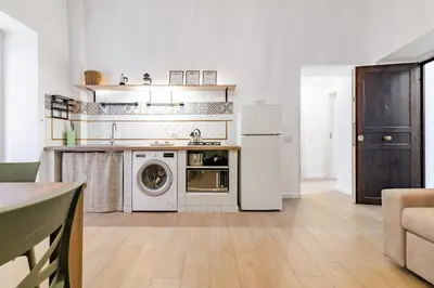 a kitchen with a refrigerator and a washer and dryer at GuestHost - Mezzojuso Central Apartment near Via Roma in Palermo
