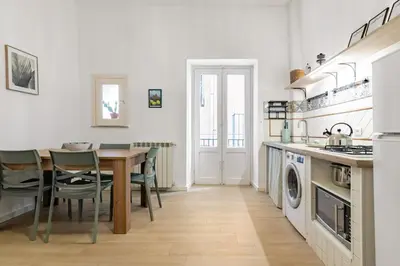 a kitchen with a table and chairs and a kitchen with a sink at GuestHost - Mezzojuso Central Apartment near Via Roma in Palermo