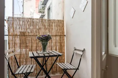 two chairs and a table with a vase of flowers at GuestHost - Mezzojuso Central Apartment near Via Roma in Palermo