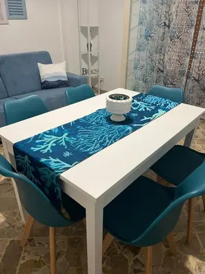 a white table and chairs with a blue table cloth on top at Vito's holiday house in Palermo