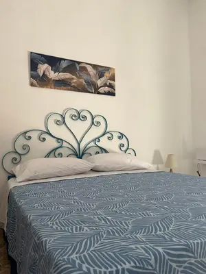 a bedroom with a bed with a blue and white bedspread at Vito's holiday house in Palermo