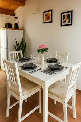 a white table with four chairs and a white refrigerator at La Terrazza del Garraffello in Palermo