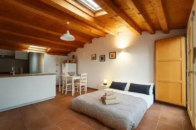 a bedroom with a large bed and a kitchen at La Terrazza del Garraffello in Palermo