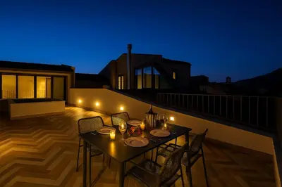 a table and chairs on a balcony at night at La Terrazza del Garraffello in Palermo