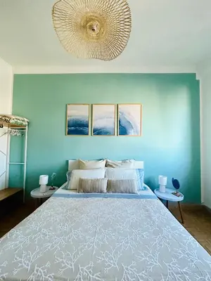 a bedroom with a large bed with a blue wall at CalaMia in Palermo
