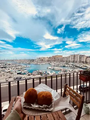 a plate of food on a table with a view of a harbor at CalaMia in Palermo