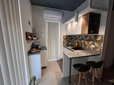 a small kitchen with a stove and a counter with stools at Cantù Home in Misilmeri