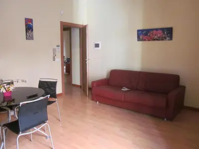 a living room with a red couch and a table at Panormus Home&Apartaments in Palermo