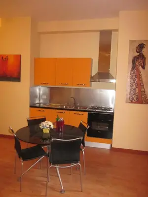 a kitchen with a table and chairs and orange cabinets at Panormus Home&Apartaments in Palermo