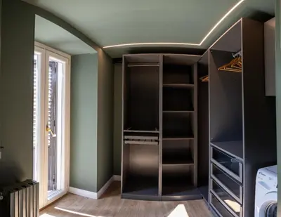 a walk in closet with black shelves and a window at Green Luxury Apartment in Palermo