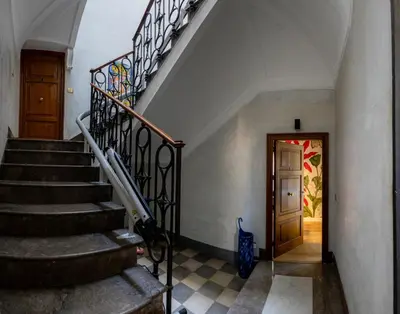 a hallway with stairs and a door with a painting on the wall at Green Luxury Apartment in Palermo
