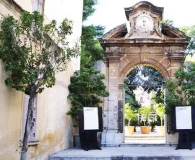 a building with an arch with a clock on it at Accasetta in Palermo