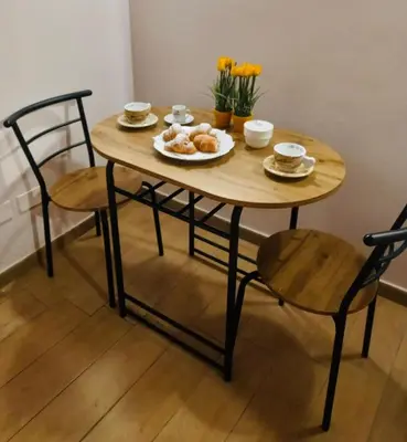 a wooden table with two chairs and plates of food on it at Accasetta in Palermo