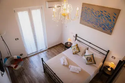 a bedroom with a bed and a chandelier at Vanda's Terrace in Palermo