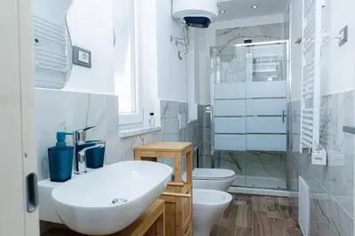 a white bathroom with a sink and a toilet at Vanda's Terrace in Palermo