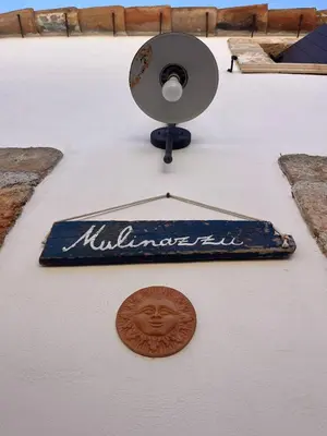 a sign on the side of a building with a light at Rustico San Leonardo in Cinisi