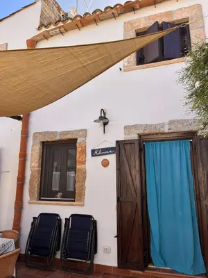 a house with two chairs in front of a door at Rustico San Leonardo in Cinisi