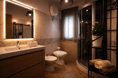 a bathroom with a toilet and a sink and a shower at Ohana House Cefalù in Lascari