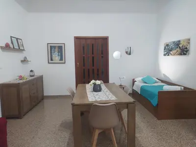 a bedroom with a desk and a bed and a table at La Rugiada-con giardino e parcheggio moto privato in Alcamo
