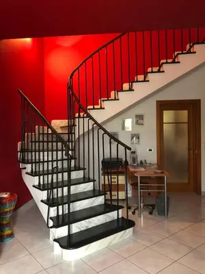 a staircase in a room with a table and a red wall at El Nur Bed & Breakfast in San Vito lo Capo
