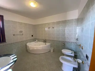 a bathroom with two toilets and a tub and a sink at El Nur Bed & Breakfast in San Vito lo Capo
