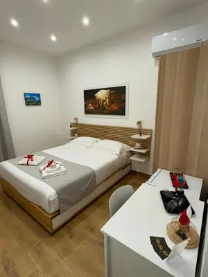 a hotel room with two beds and a desk at B&B Central Station in Palermo
