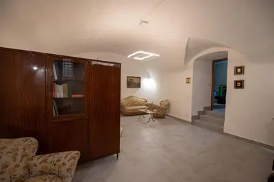 a living room with a wooden cabinet and chairs at Le 4 Stagioni-nelcuorediCorleone in Corleone