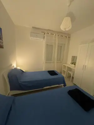 a bedroom with two beds and a table in it at La Bella Vista in Palermo