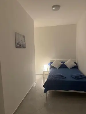 a bedroom with a blue bed in a white room at La Bella Vista in Palermo
