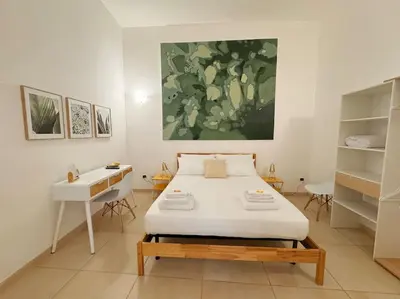 a living room with a couch and a table and a clock at L'alcova di nonna Caterina - Guest House in Terrasini