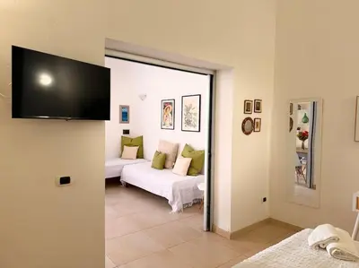 a bedroom with a bed and a desk and a painting at L'alcova di nonna Caterina - Guest House in Terrasini