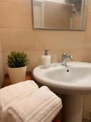 a bathroom with a sink and a mirror and towels at L'alcova di nonna Caterina - Guest House in Terrasini