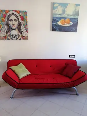 a red couch in a room with a painting on the wall at Aurora house in Palermo