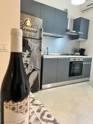 a bottle of wine sitting on a table in a kitchen at Casa Vacanze Kristel in Balestrate