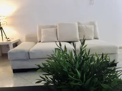 a white couch in a living room with a plant at Casa Vacanze Kristel in Balestrate
