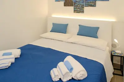 a bedroom with a blue and white bed with towels at Stella del Sud in Palermo