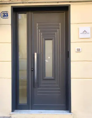 a gray door on a building with a sign on it at Stella del Sud in Palermo