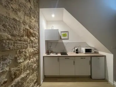 a kitchen with a counter and a brick wall at Calderai Suite centro storico Palermo in Palermo