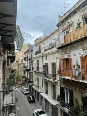 a city street with cars parked in front of buildings at Calderai Suite centro storico Palermo in Palermo
