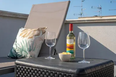 a bottle of wine and two wine glasses on a table at La Dolce Vista - Magaggiari in Terrasini