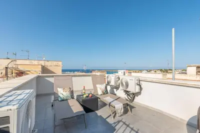 a rooftop patio with a view of the ocean at La Dolce Vista - Magaggiari in Terrasini