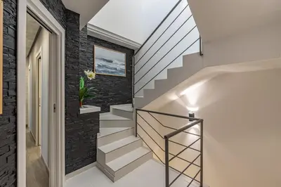 a staircase in a home with a black brick wall at La Dolce Vista - Magaggiari in Terrasini