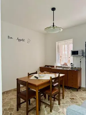 a kitchen with a wooden table and chairs in a room at Casa Katarina in Calatafimi