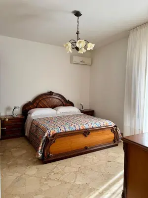 a bedroom with a bed and a chandelier at Casa Katarina in Calatafimi