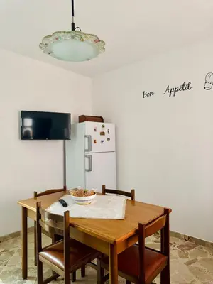 a kitchen with a table with chairs and a refrigerator at Casa Katarina in Calatafimi
