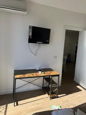 a desk with a television hanging on a wall at Scilia casa vacanza in Palermo