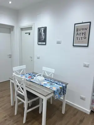 a dining room table with two chairs and a table with a cloth on it at Scilia casa vacanza in Palermo