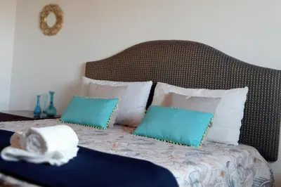 a bed with blue and white pillows on it at Ciuri CiuriHome in Balestrate